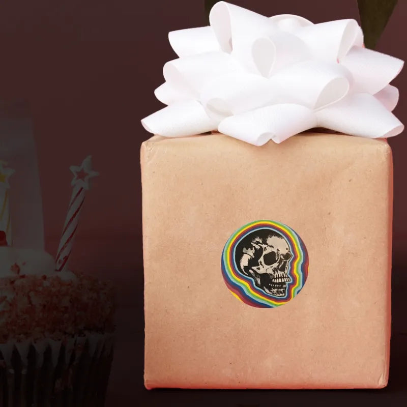 Smaller sticker of a skull with rainbow around it, prototyped on the side of a wrapped gift.