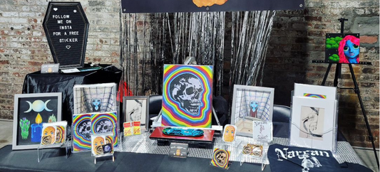 a table set up with various products made by bitchnuggetart. photo was taken at a recent pop-up market.