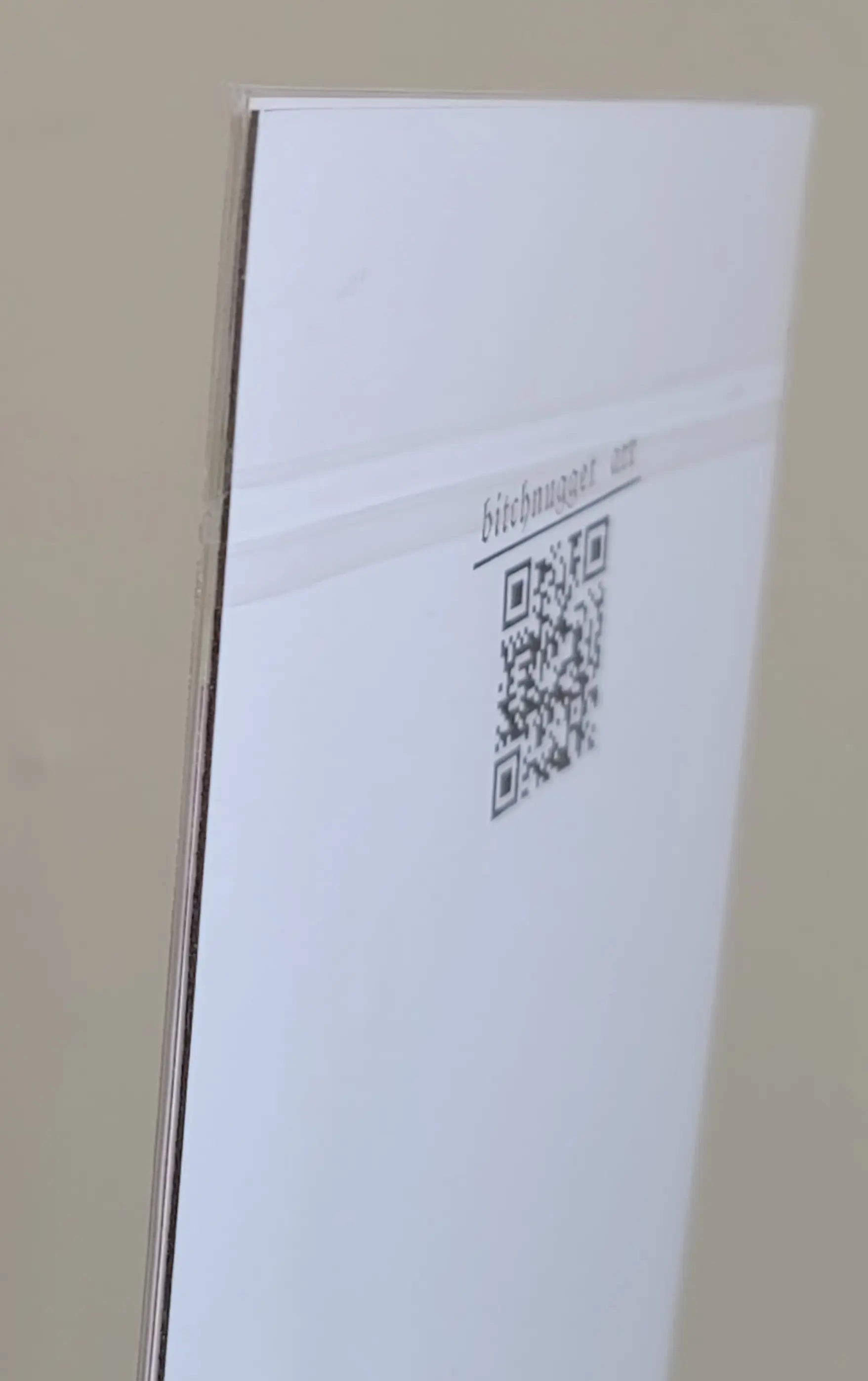 white piece of cardboard with a black QR code stamped