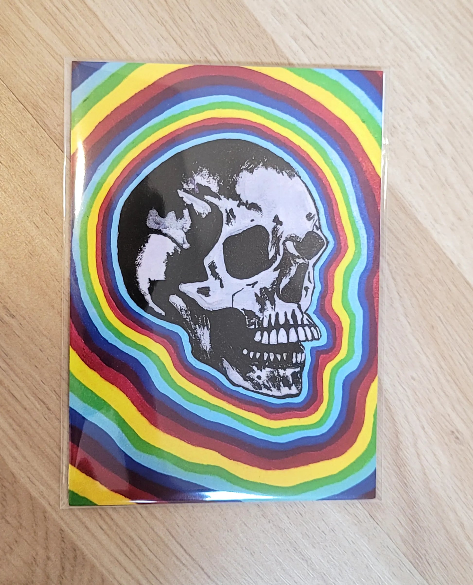 painting of a skull with a rainbow background