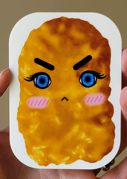 Grumpy chicken nugget sticker held in someone's hand.